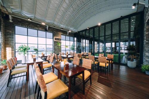 une salle à manger avec tables, chaises et fenêtres dans l'établissement The Classic by Hotelone, à Changdong-ni