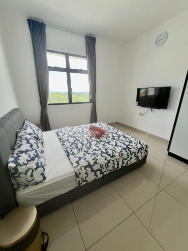 a bedroom with a bed and a window and a television at Appartment Desaru Utama in Bandar Penawar