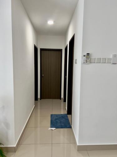 a hallway with a door and a blue rug at Appartment Desaru Utama in Bandar Penawar