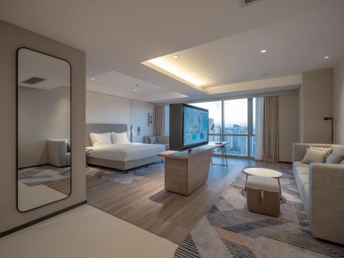a hotel room with a bed and a large mirror at Holiday Inn Express Wuxi Taihu by IHG in Wuxi