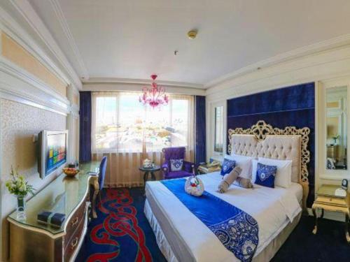 a bedroom with a large bed and a chandelier at Hohhot Inner Mongolia Hotel in Hohhot
