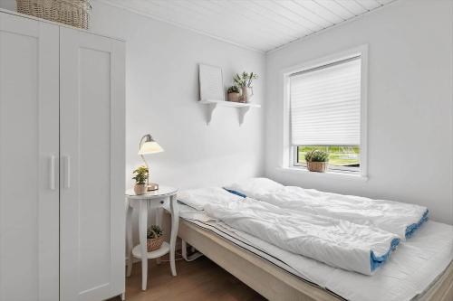 ein weißes Schlafzimmer mit einem Bett und einem Fenster in der Unterkunft OH362 Storvorde - Kongeørnen 74 in Storvorde