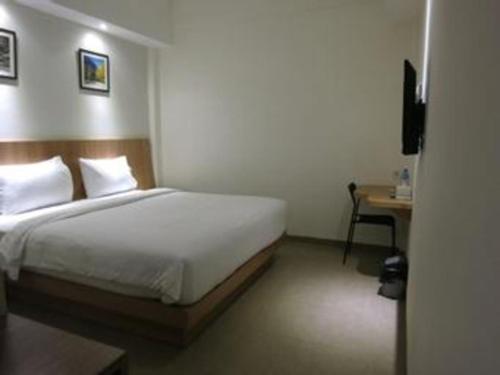 a bedroom with a bed and a desk and a bed sidx sidx sidx at Hart Hotel Arjuna in Gili Trawangan