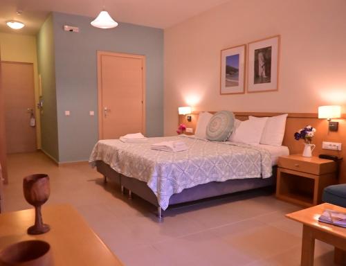 a bedroom with a bed and a living room at Hotel Estia in Finikounta