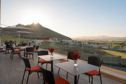 a patio with tables and chairs and a mountain at Ayan Zalaat in Ulaanbaatar