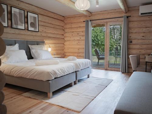 a bedroom with a bed in a room with wooden walls at Logis Hôtel-Restaurant Domaine de Montecristo in Bourguignons