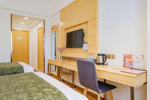 a hotel room with a desk and a television at GreenTree Inn Shanghai Jingan Railway Station Xinzha Road Business Hotel in Shanghai