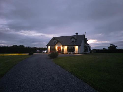 ein Haus mit nachts eingeschaltetem Licht in der Unterkunft The Single Room in Killinick
