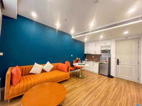 a living room with an orange couch and a blue wall at Sunset town Phú Quốc in Phu Quoc