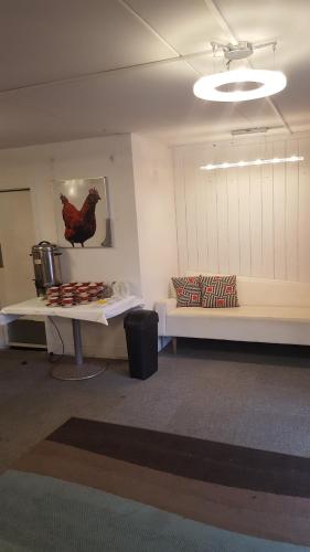 a room with a couch and a table with a chicken on the wall at Walton Park Motor Lodge in Warkworth