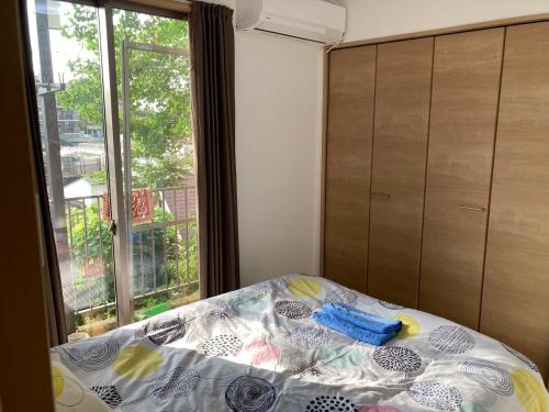 a bed in a room with a window and a bedspread at Sweet house 101 東武練馬101 in Tokyo