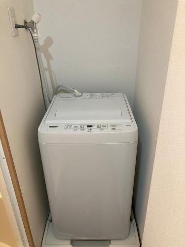a white washer and dryer in a small bathroom at Sweet house 101 東武練馬101 in Tokyo