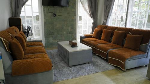 a living room with two couches and a table at Diyar Villas Puncak M6-11 in Puncak