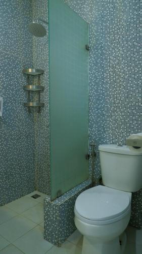 a bathroom with a toilet and a glass shower at Diyar Villas Puncak M6-11 in Puncak