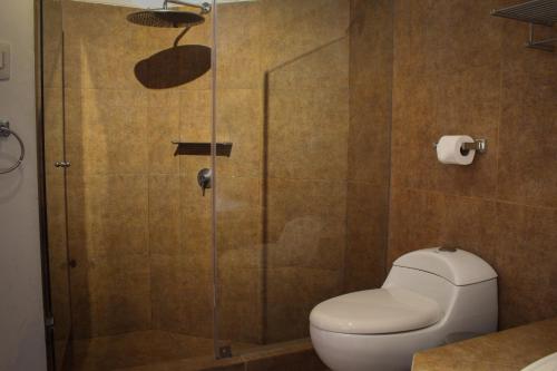 a bathroom with a toilet and a glass shower at Hotel Boutique La Angostura in Ica