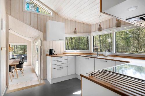 a kitchen with white cabinets and a table and windows at 2722-Nexo-Jaegerstien-6 in Neksø
