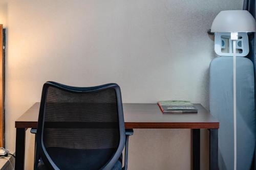 a desk with a chair and a lamp and a book at INEZ Homestay in Timuran