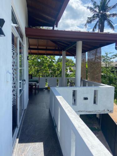 Un patio al aire libre con una encimera blanca y una palmera. en Mirissa Gold Rush Guest House, en Mirissa