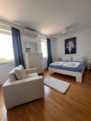 a bedroom with a bed and a couch at Sea View Apartment in Matulji