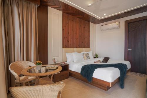 a hotel room with a bed and a table with a laptop at SaffronStays Library Enclave Maharajah Suite - 1-BHK Luxury Apt with Valley View, Mall Road Mussoorie in Mussoorie