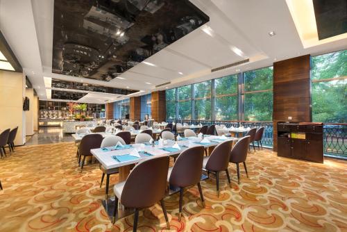 een conferentieruimte met tafels en stoelen en grote ramen bij Grand Skylight International Hotel Shenzhen Guanlan, Near Metro Station, Huawei, Foxcnn, Shenzhen North Railway in Bao'an