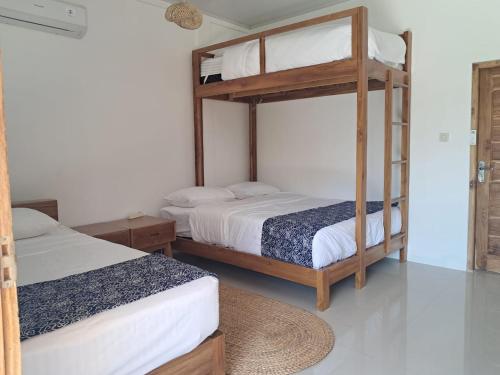 a bedroom with two bunk beds and a rug at Wind and Sea at Arista Lakey Peak House in Huu