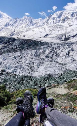 a person laying on the ground looking at a mountain at Rakaposhi Base Camp Site in Minapin