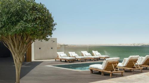 a row of lounge chairs next to a swimming pool at New Spirit Dakhla in Dakhla
