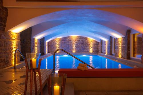 a swimming pool in a building with lights at Boscolo Lyon Hotel & Spa in Lyon