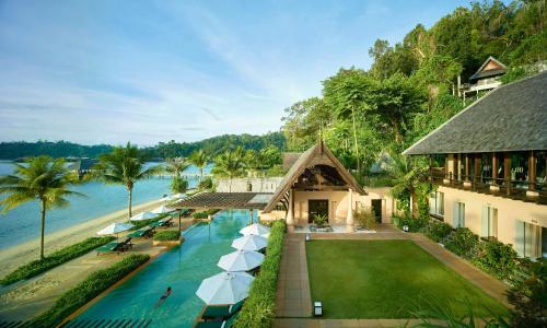 an aerial view of a resort with a pool and umbrellas at Gaya Island Resort, Kota Kinabalu - a Small Luxury Hotels of the World in Gaya Island