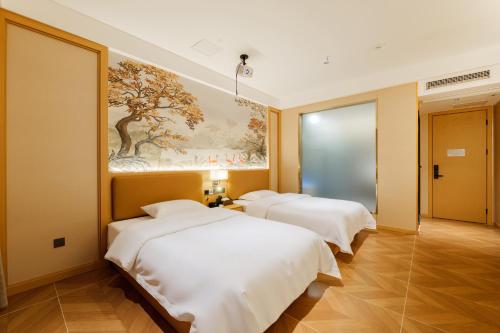 three beds in a room with a painting on the wall at OK Smart Hotel 