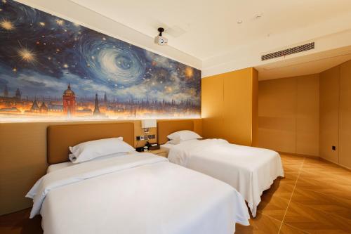 two beds in a room with a painting on the wall at OK Smart Hotel 