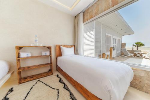 a bedroom with a bed and a large window at New Spirit Dakhla in Dakhla