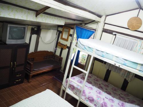 甘烹碧三J旅馆的客房设有两张双层床和电视。