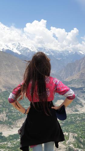 a woman is standing on top of a mountain at Rakaposhi Base Camp Site in Minapin