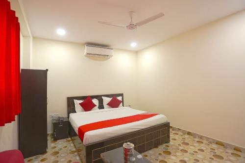- une chambre dotée d'un lit avec des draps rouges et blancs dans l'établissement Hotel O Three Kings, à New Delhi