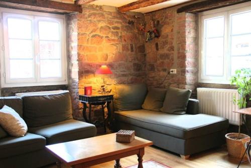 a living room with two couches and a table at l'ancienne ferme in Epfig