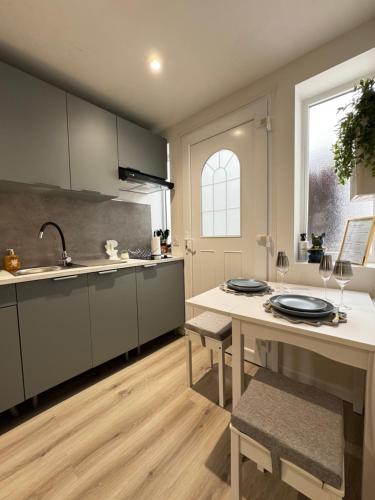 a kitchen with a sink and a table with chairs at Maisonnette neuve, centre-ville, 20mn de Paris in Herblay