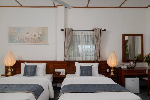 two beds in a room with two lamps at Mirage Kandyan Heights in Kandy