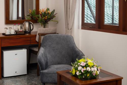 a room with a chair and a table with flowers at Mirage Kandyan Heights in Kandy