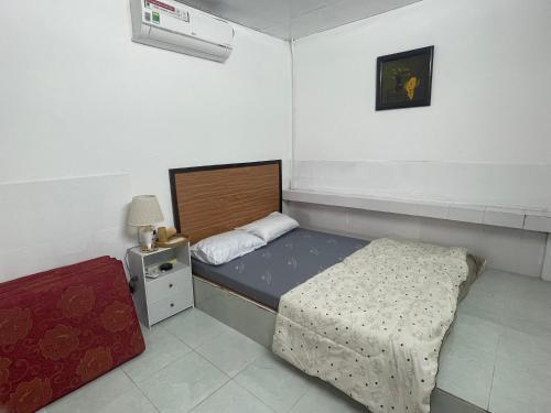 a small bedroom with a bed and a night stand at Homestay & Cafe Xã Đảo 