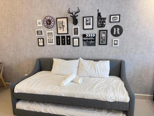 a bed in a room with pictures on the wall at Tamarind Square Edusphere 3min 6pax dualkey in Cyberjaya