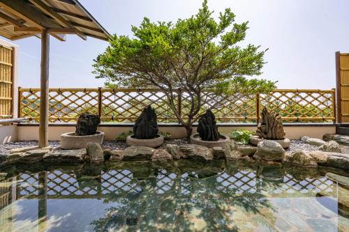 a pool with three statues in front of a fence at Shima Beach Hotel in Toba