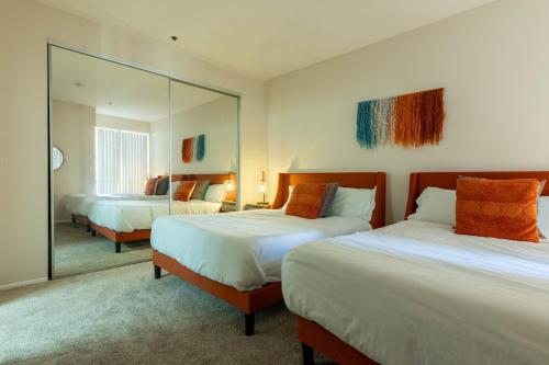 ein Hotelzimmer mit zwei Betten und einem Spiegel in der Unterkunft Marvelous 2BR 2BA Apartment in Los Angeles