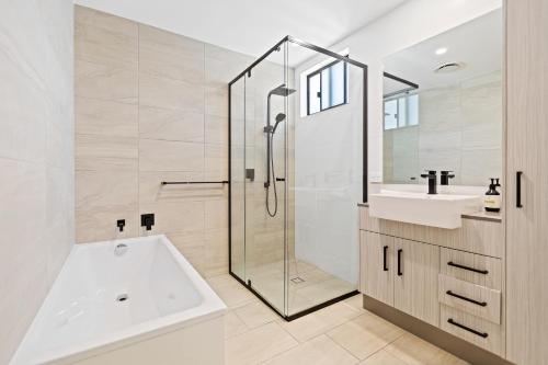凯恩斯Mountain Air and Modern Flair 'Your Cairns Getaway'的带浴缸、水槽和淋浴的浴室