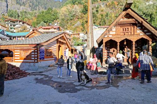 a group of people standing in front of a wooden building at Capital O Himalayan Travels in Manāli