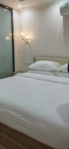 Ein Bett oder Betten in einem Zimmer der Unterkunft Shiyi Business Hotel Pazhou-Free shuttle bus for canton fair