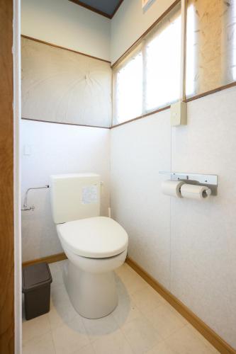 a small bathroom with a toilet and a window at グッドタイム細越 in Aomori