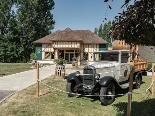 an old truck parked in front of a building at Logis Hôtel-Restaurant Domaine de Montecristo in Bourguignons