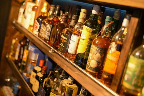 a bunch of bottles of alcohol on a shelf at グッドタイム細越 in Aomori